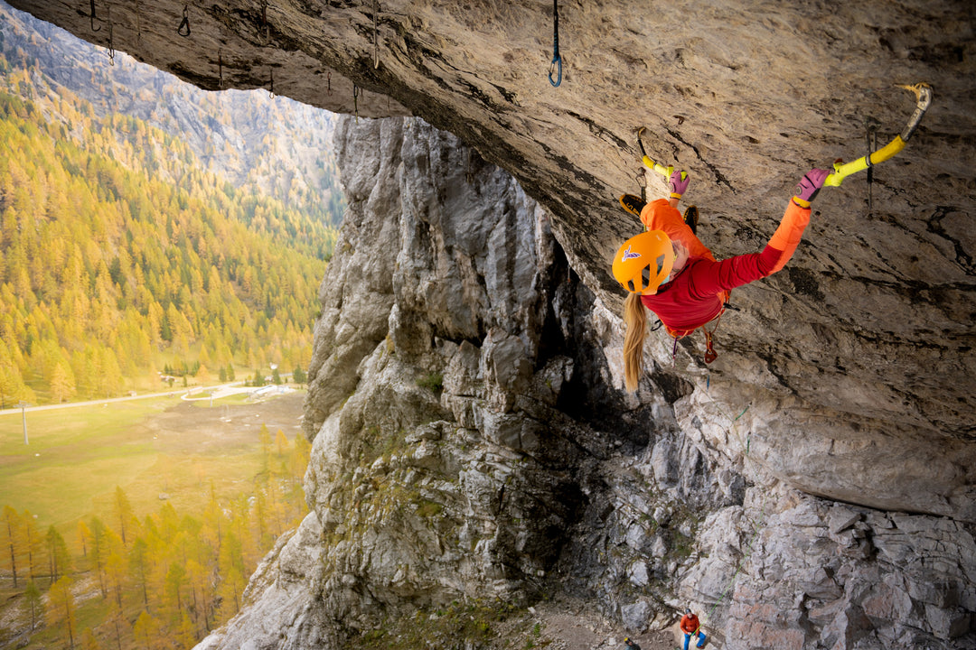a woman drytooling in a cave